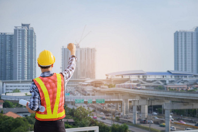 工程師或建筑師與防護(hù)安全帽檢查建筑圖紙呼叫支持團(tuán)隊(duì)在建筑工地。工程建筑和建筑施工理念。軟焦點(diǎn)